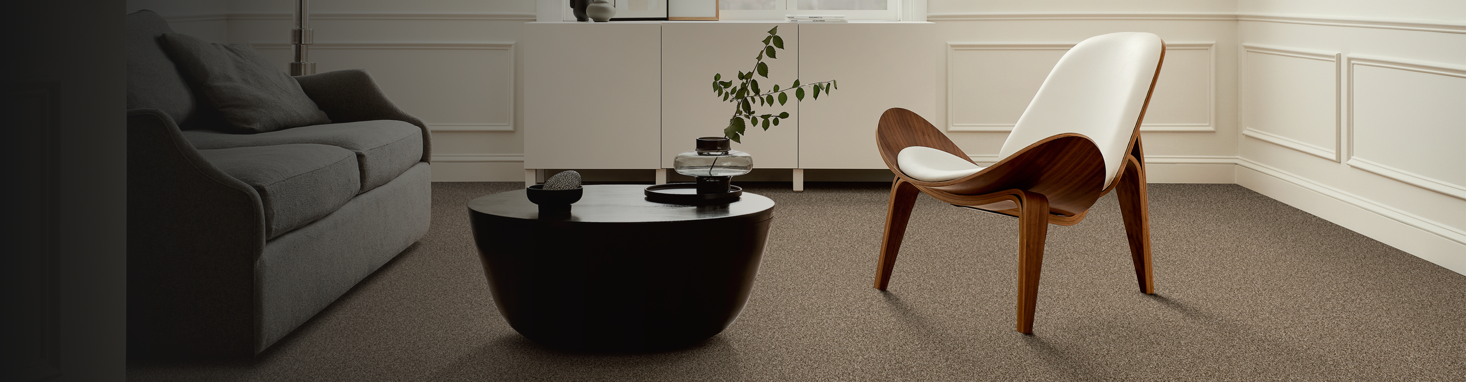 Sitting area with brown carpet with a modern accent chair